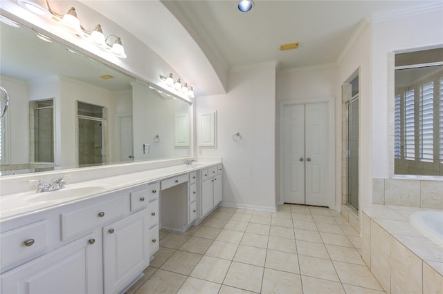 bathroom featuring tile patterned flooring, crown molding, a garden tub, a stall shower, and a sink