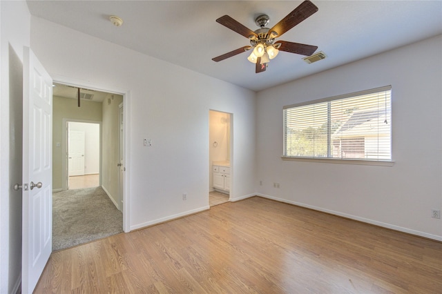 unfurnished bedroom featuring visible vents, light wood-style flooring, ensuite bath, and baseboards