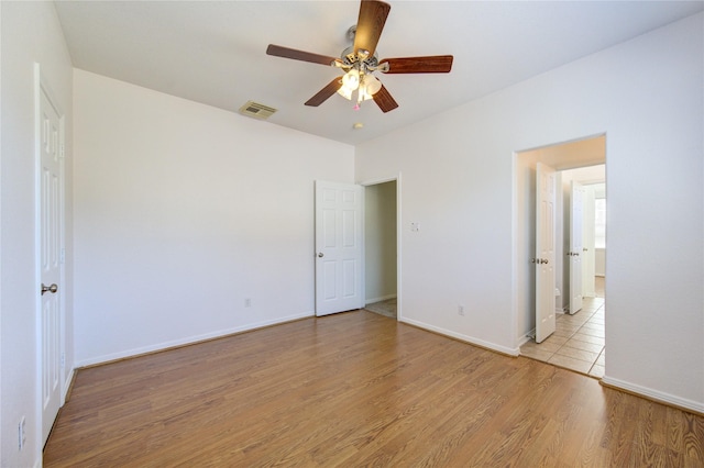 unfurnished bedroom with a ceiling fan, baseboards, visible vents, and light wood finished floors