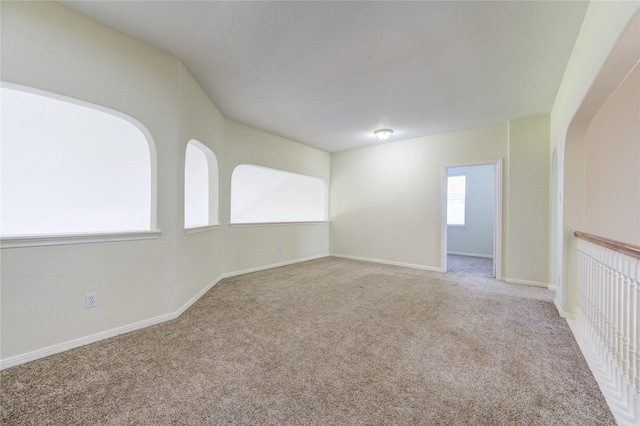 carpeted empty room with baseboards