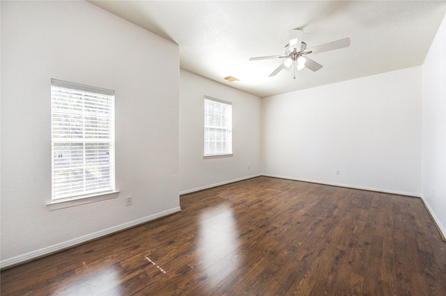 spare room featuring visible vents, baseboards, a ceiling fan, and wood finished floors