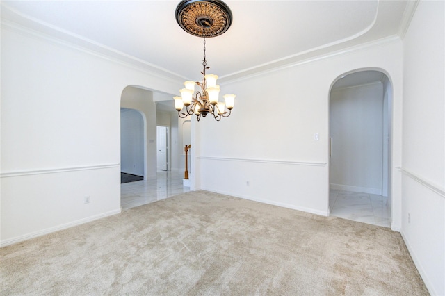 carpeted empty room featuring arched walkways, a notable chandelier, baseboards, and ornamental molding