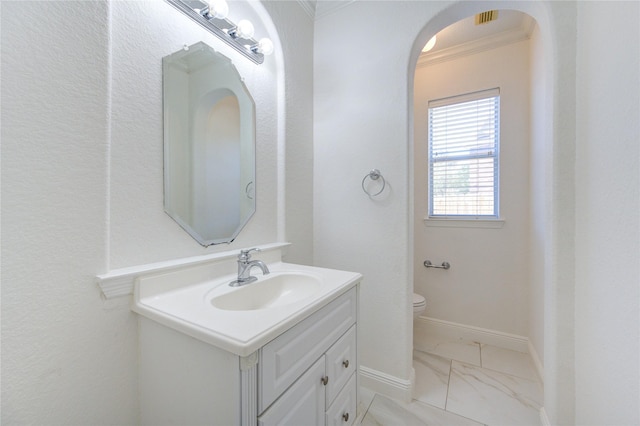 bathroom featuring toilet, marble finish floor, ornamental molding, baseboards, and vanity