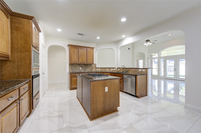 kitchen featuring a peninsula, a center island, arched walkways, and stainless steel appliances