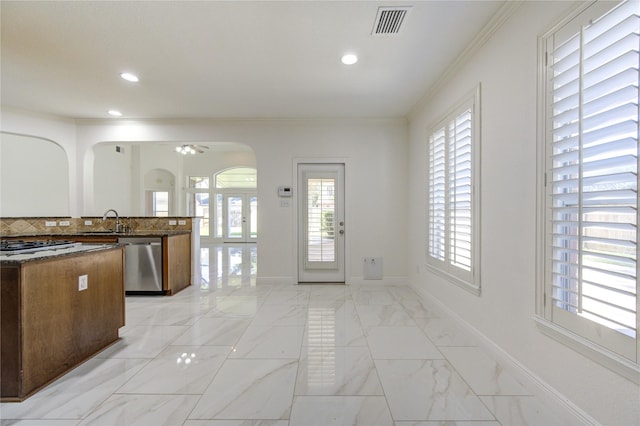 kitchen with marble finish floor, a sink, stainless steel appliances, arched walkways, and baseboards