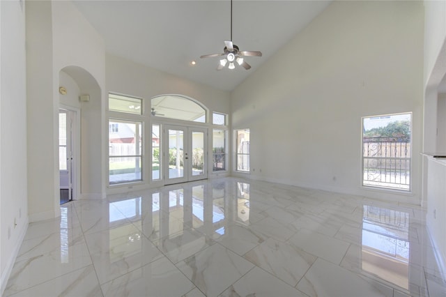 empty room featuring french doors, high vaulted ceiling, marble finish floor, and ceiling fan