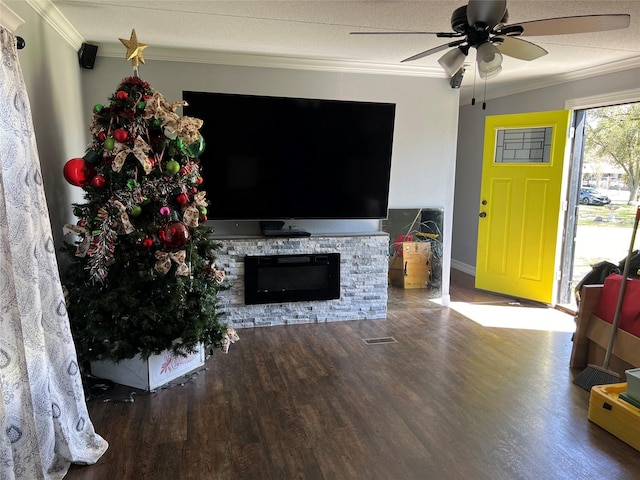 unfurnished living room with visible vents, wood finished floors, a fireplace, crown molding, and ceiling fan