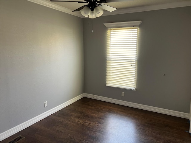 spare room with dark wood-style floors, visible vents, baseboards, ornamental molding, and ceiling fan