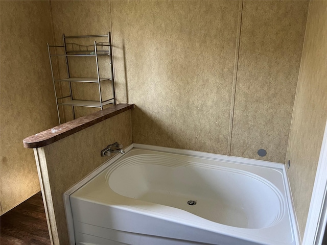 full bathroom featuring a garden tub and wood finished floors