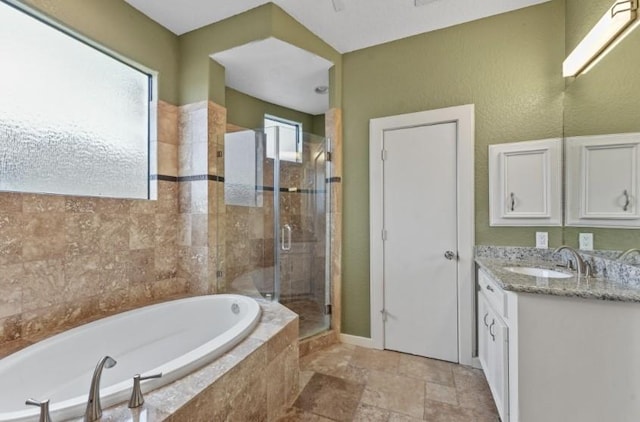 bathroom featuring vanity, a garden tub, a shower stall, and stone finish flooring