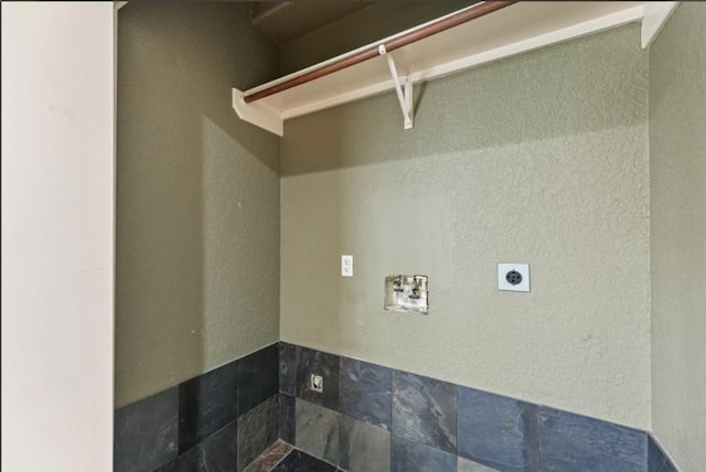 laundry area featuring laundry area, hookup for an electric dryer, a textured wall, and washer hookup