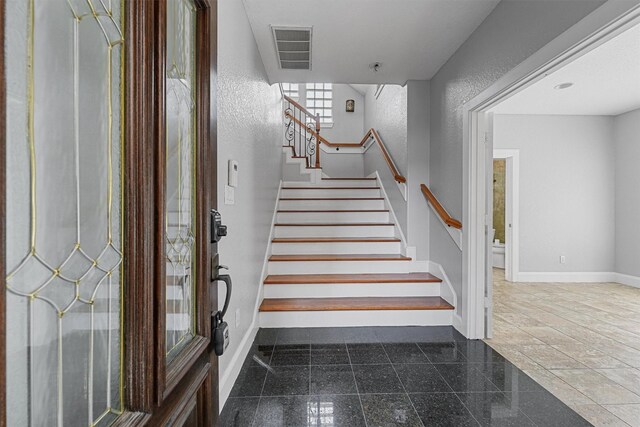 6132 Maxie St, Houston, TX 77007 - stairway featuring granite floors, baseboards, and a textured wall