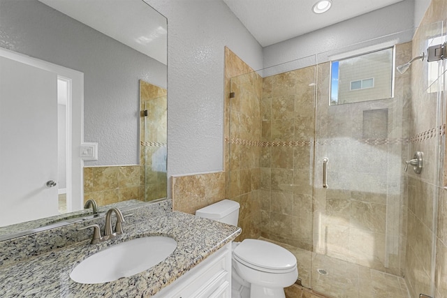 6132 Maxie St, Houston, TX 77007 - full bath featuring a shower stall, tile walls, toilet, a textured wall, and vanity
