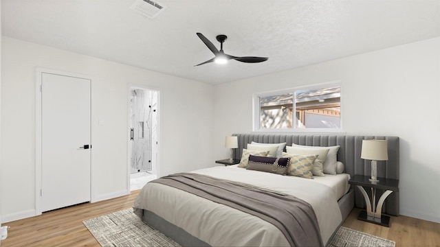 bedroom with visible vents, ensuite bathroom, light wood-style flooring, and a ceiling fan