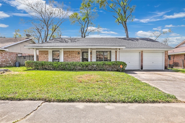 ranch-style house with a front yard, brick siding, a garage, and driveway