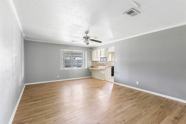 unfurnished living room with crown molding, baseboards, light wood-style floors, and a ceiling fan