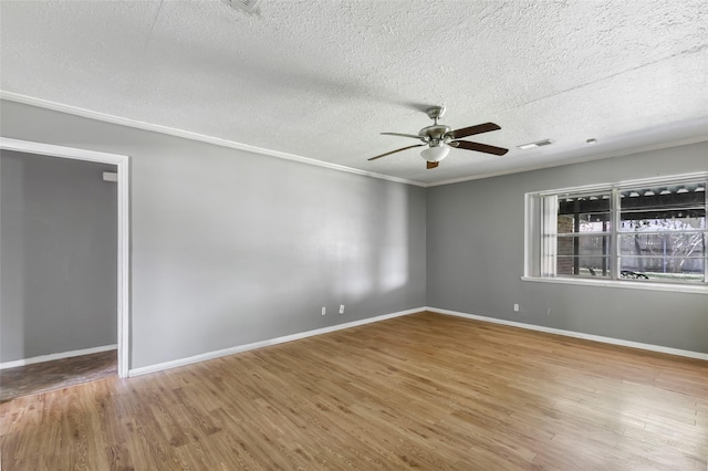 empty room with visible vents, baseboards, ceiling fan, wood finished floors, and a textured ceiling