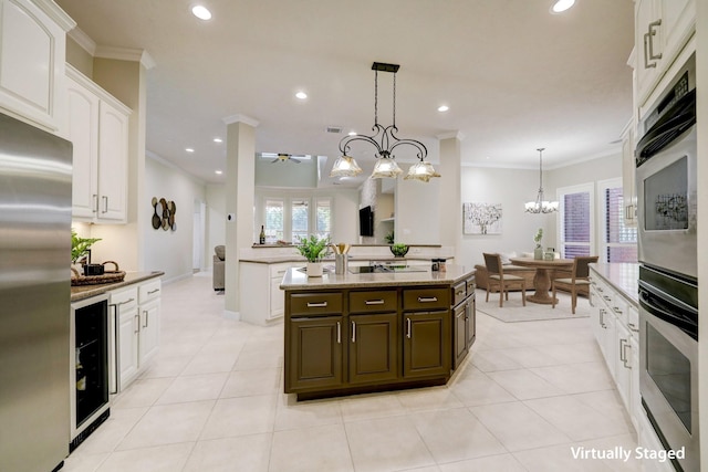 kitchen featuring crown molding, recessed lighting, stainless steel appliances, a notable chandelier, and white cabinetry