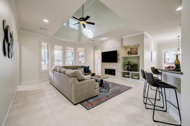 living room featuring built in shelves, a ceiling fan, visible vents, a fireplace, and crown molding