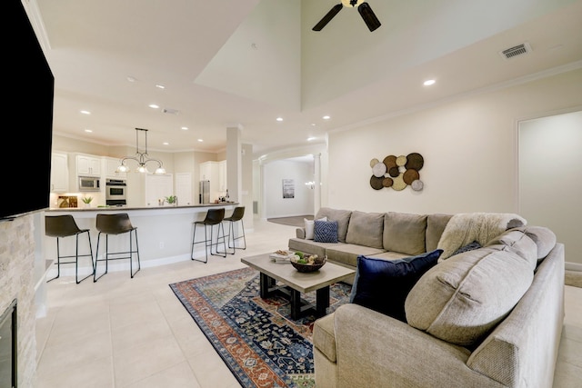 living area featuring light tile patterned floors, visible vents, recessed lighting, ceiling fan, and crown molding