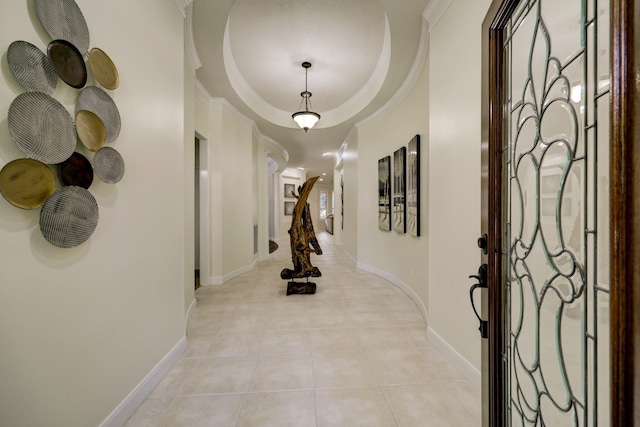 entryway featuring light tile patterned floors, baseboards, crown molding, and a tray ceiling