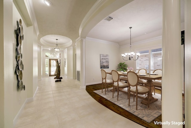 dining area featuring visible vents, arched walkways, ornamental molding, and decorative columns