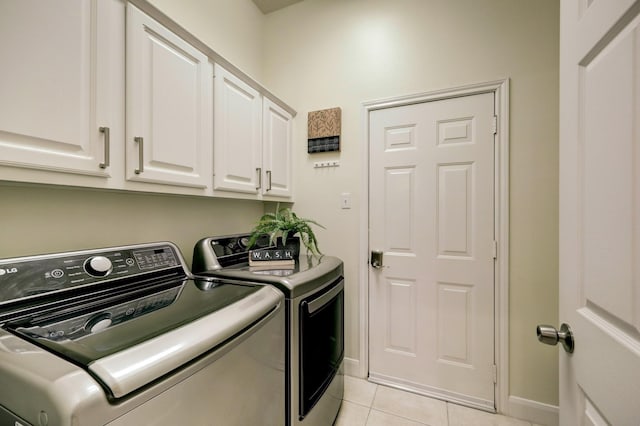 laundry area featuring cabinet space, light tile patterned floors, washing machine and dryer, and baseboards