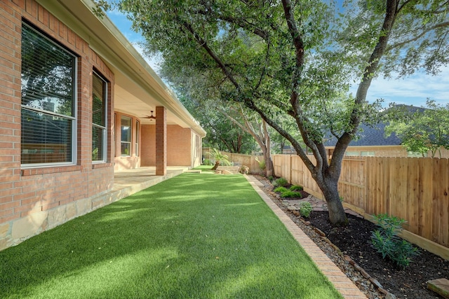 view of yard with a fenced backyard, a patio area, and ceiling fan