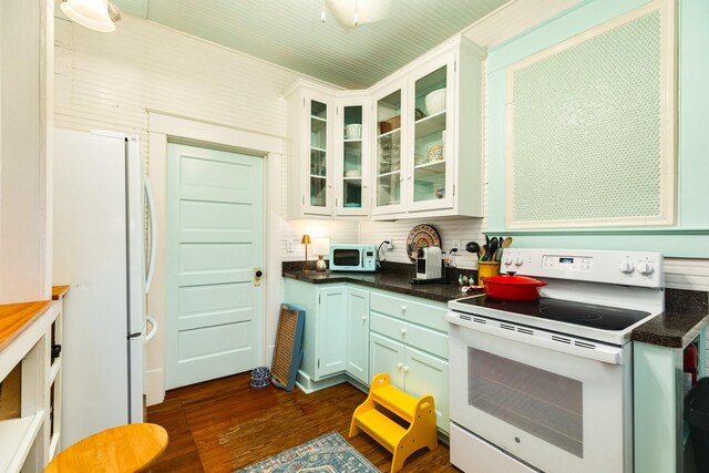1411 13th St, Galveston, TX 77550 - kitchen featuring white appliances, dark wood-type flooring, dark countertops, glass insert cabinets, and white cabinets