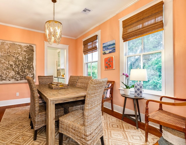 1411 13th St, Galveston, TX 77550 - dining room with wood finished floors, a chandelier, baseboards, and ornamental molding