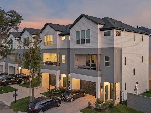 view of front facade with a garage, concrete driveway, and fence