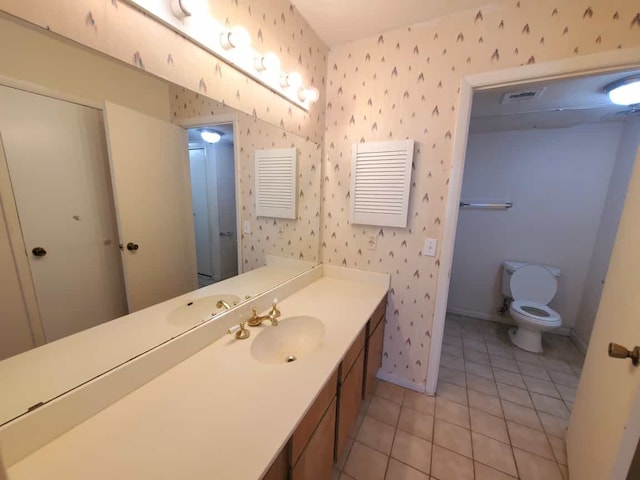 bathroom with toilet, wallpapered walls, and baseboards