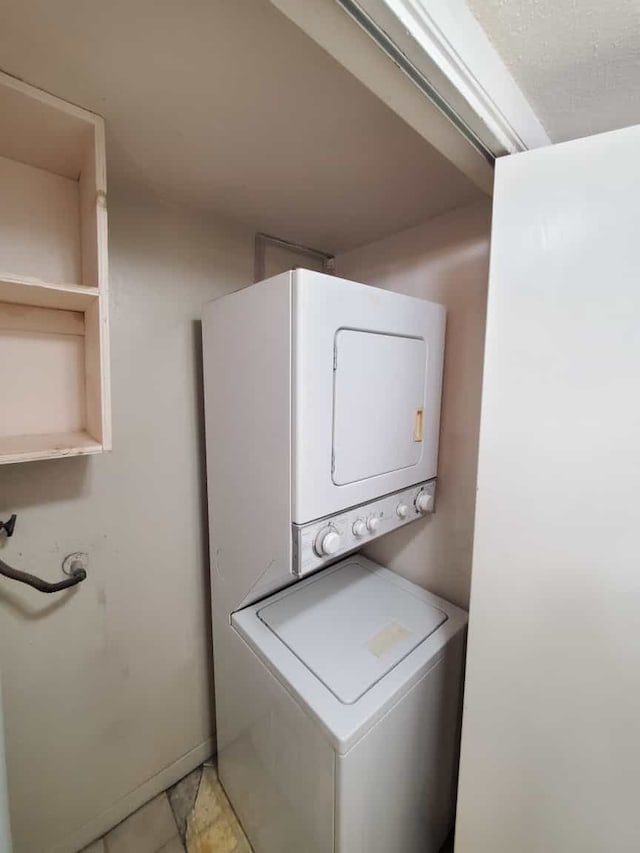 laundry area with stacked washer / drying machine and laundry area