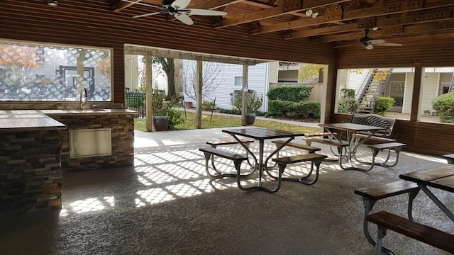 view of patio / terrace with area for grilling, outdoor dining space, a ceiling fan, a sink, and stairway