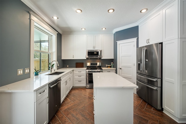 kitchen featuring a sink, stainless steel appliances, white cabinets, crown molding, and a center island