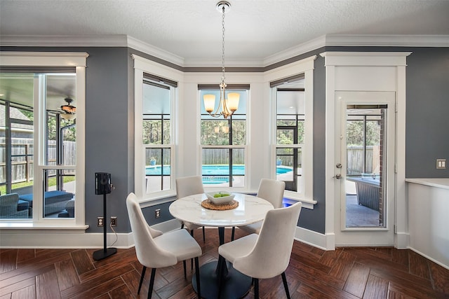 dining space featuring baseboards, a textured ceiling, an inviting chandelier, and crown molding