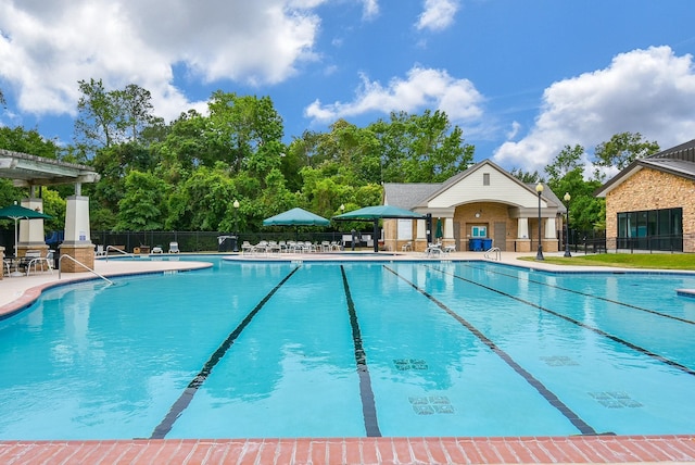 pool with a patio and fence