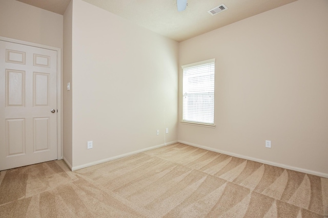 spare room with carpet, visible vents, and baseboards