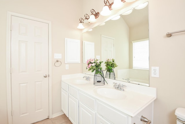 bathroom featuring double vanity, toilet, tile patterned floors, and a sink