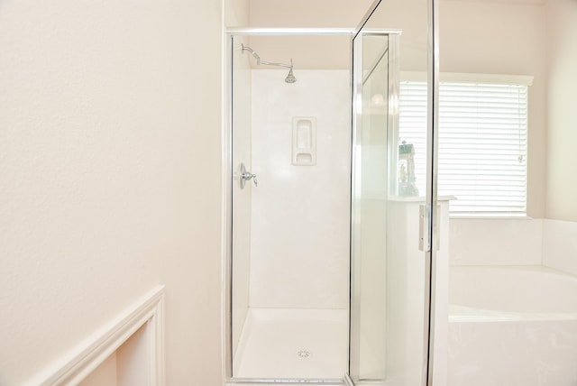 bathroom with a garden tub and a shower stall