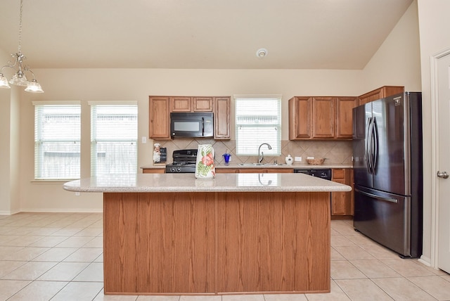 kitchen featuring black appliances, light tile patterned flooring, light countertops, and a sink