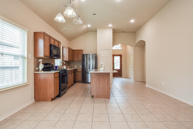 kitchen with black appliances, arched walkways, light tile patterned flooring, light countertops, and decorative backsplash