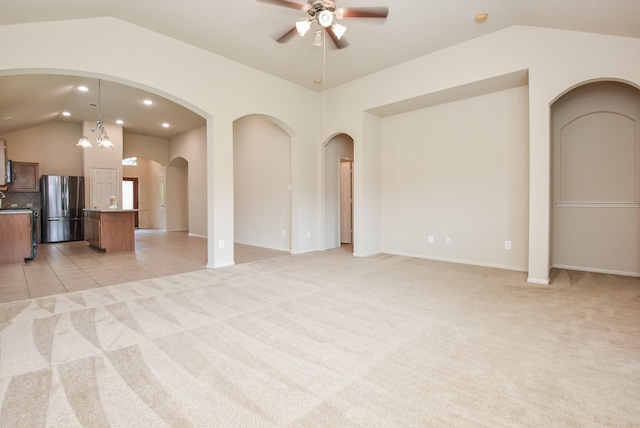 unfurnished living room with a ceiling fan, recessed lighting, arched walkways, light tile patterned floors, and light colored carpet