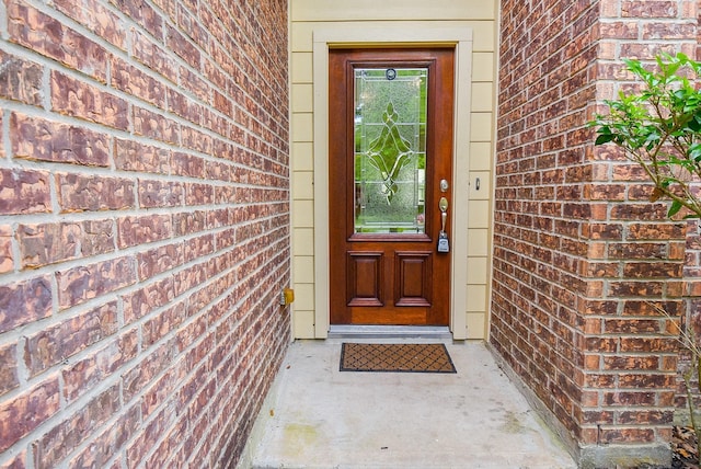 doorway to property with brick siding