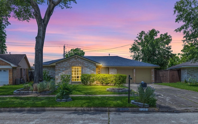 ranch-style house with a garage, driveway, a front yard, and brick siding