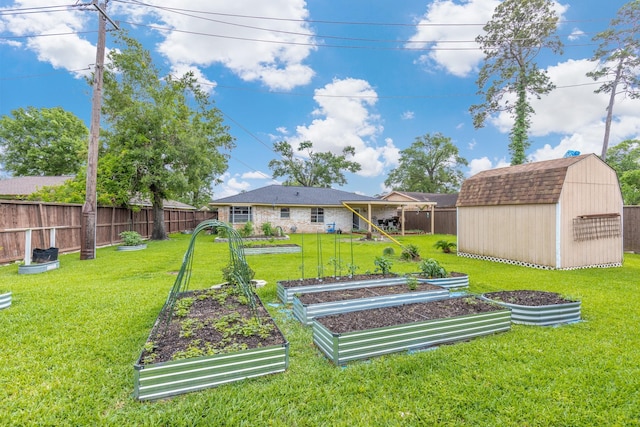 view of yard with an outdoor structure, a garden, fence, and a storage unit