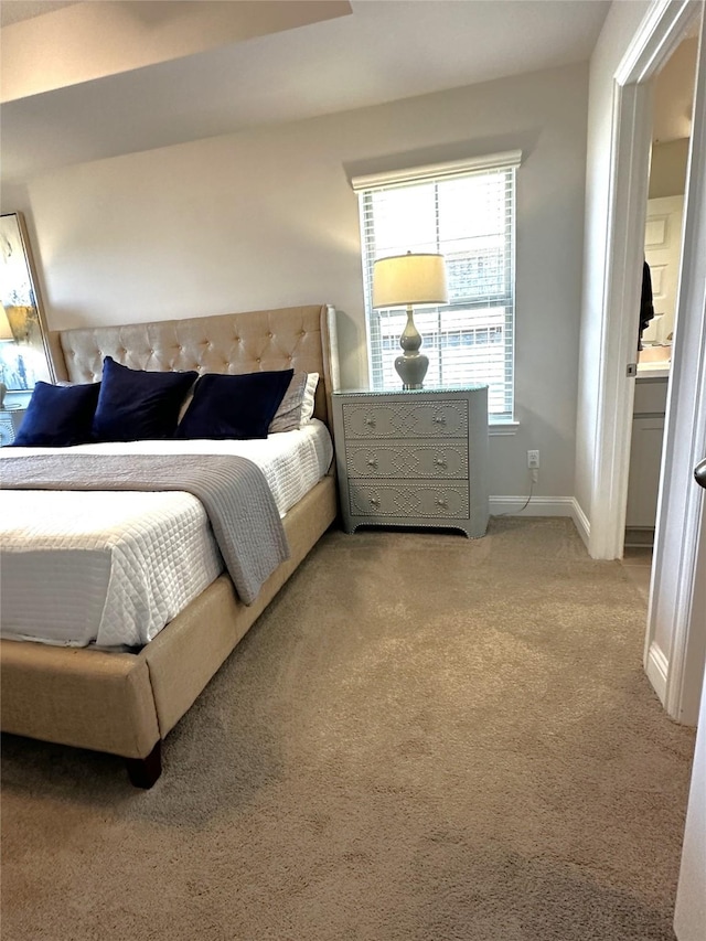 bedroom with light colored carpet and baseboards