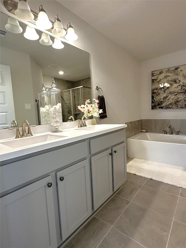 bathroom featuring tile patterned flooring, a shower stall, double vanity, and a sink