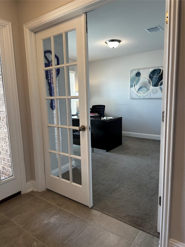 doorway with visible vents, french doors, carpet flooring, and tile patterned flooring