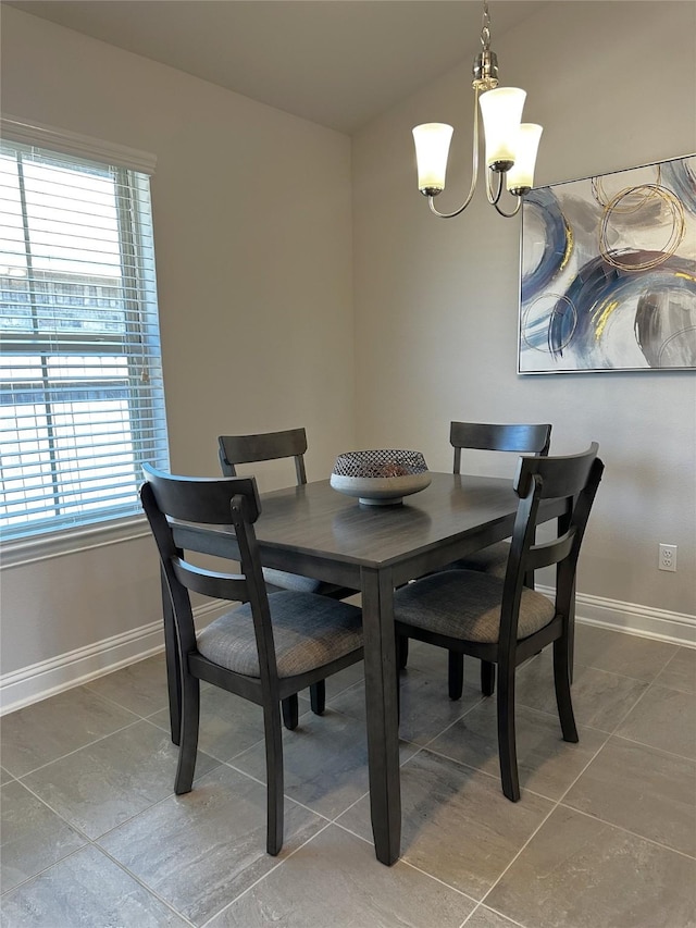 dining area featuring light tile patterned floors, baseboards, and a chandelier